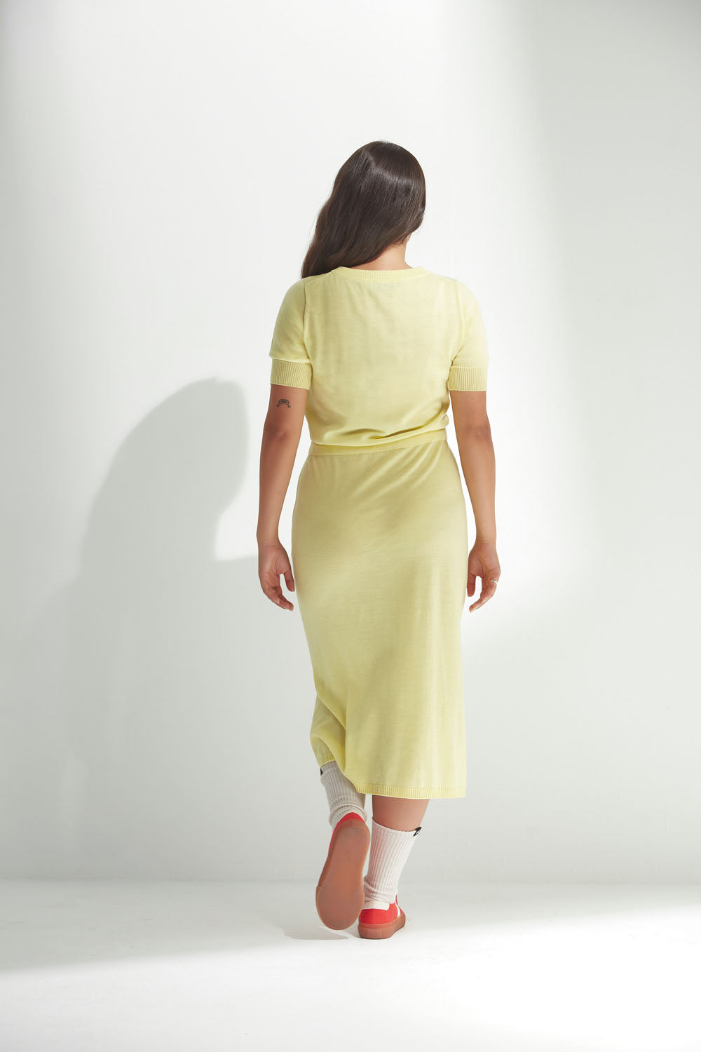 Woman wearing a light yellow dress on a white background