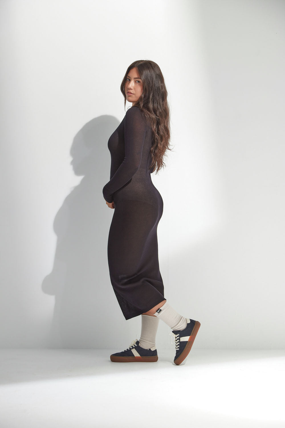 Woman wearing a long black dress against a white background