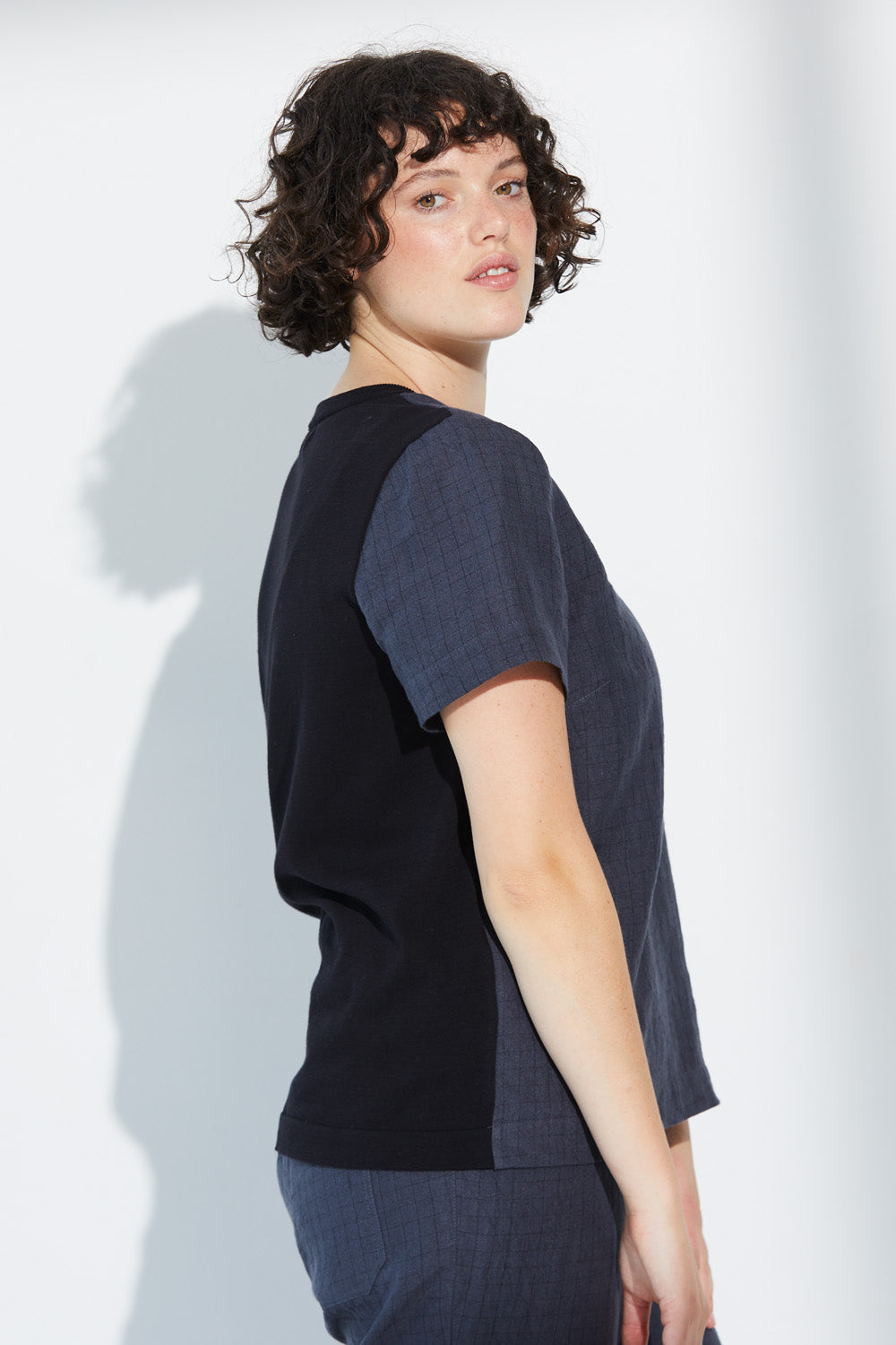 A woman wearing a charcoal-coloured Standard Issue Grid Linen Tee.