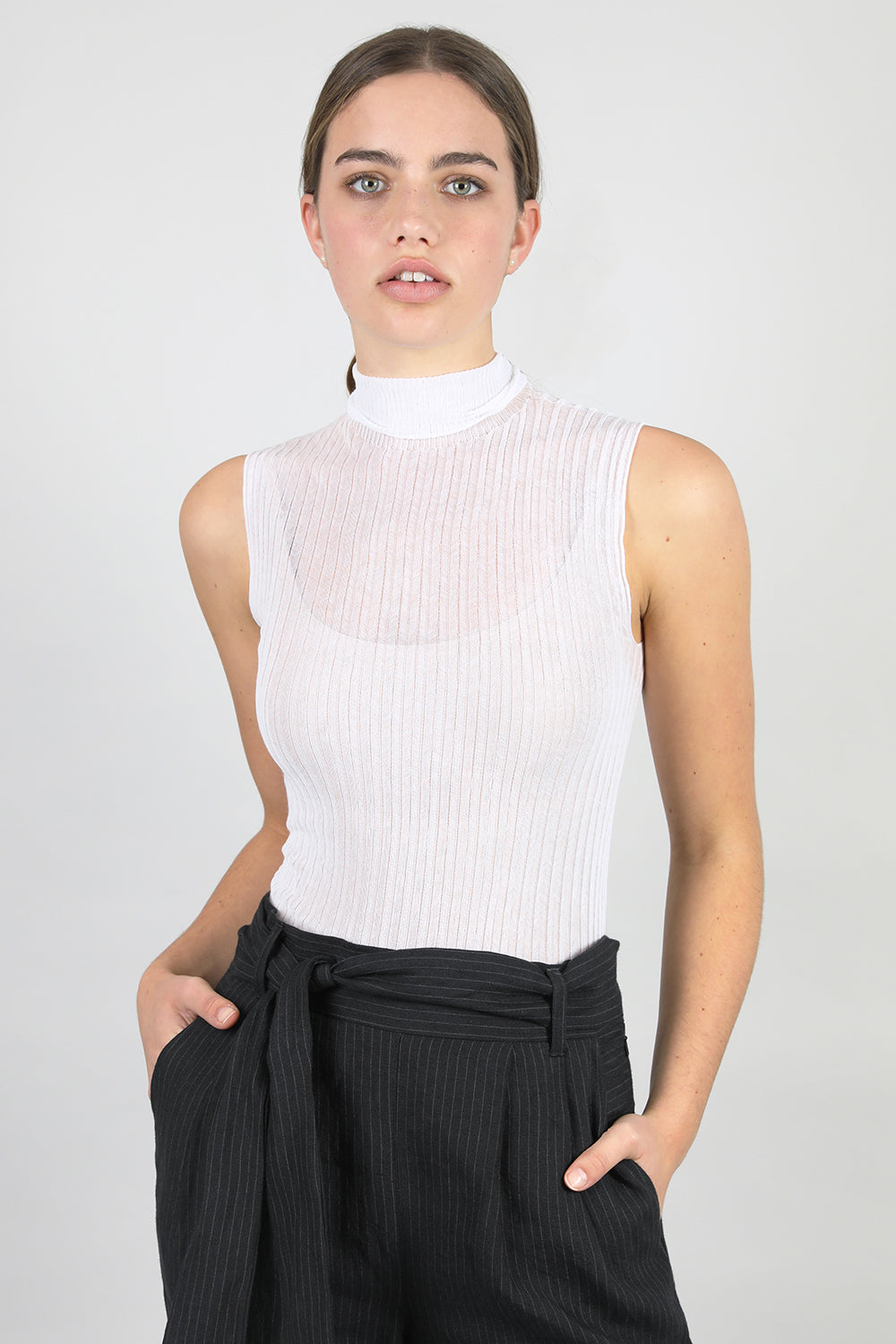A woman standing wearing a white Standard Issue Cotton Tulle High Neck skivvy.