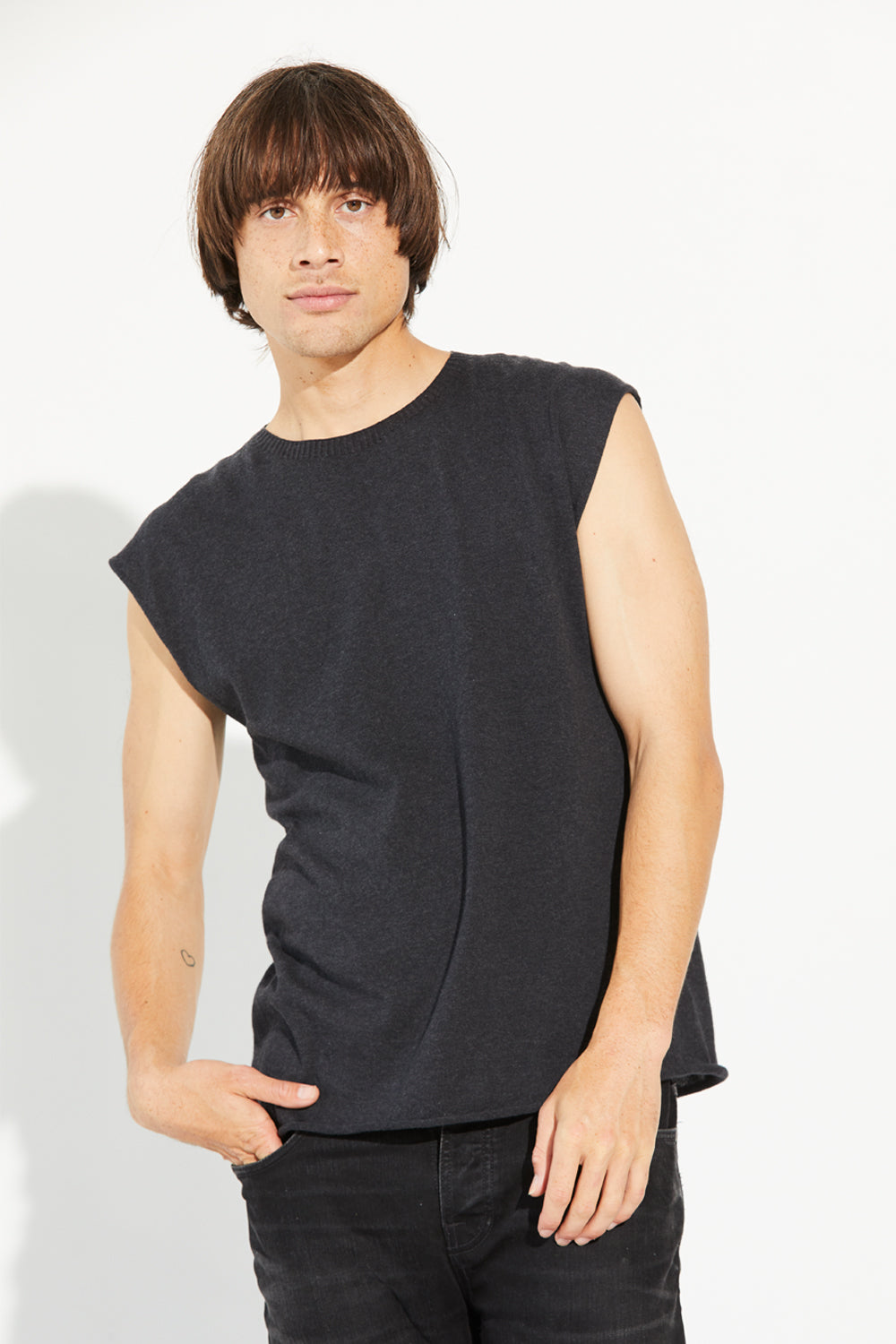 A man standing wearing a charcoal-coloured Standard Issue Cotton Kiri Tank.