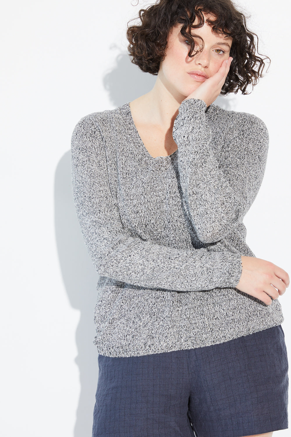 A woman wearing a twist-coloured Standard Issue Linen V jumper.