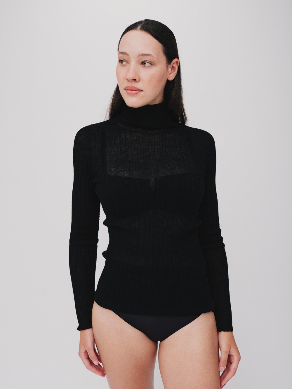 Woman wearing a sheer black tulle against a white background