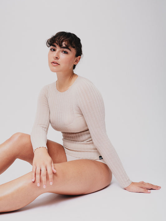 Woman wearing a pearl white ribbed merino tulle on a white background