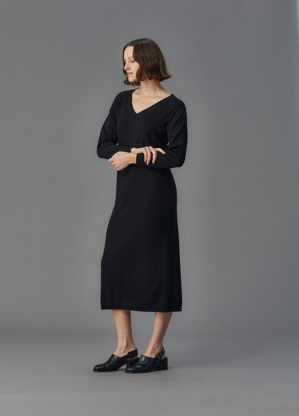Woman wearing a black dress against a gray background