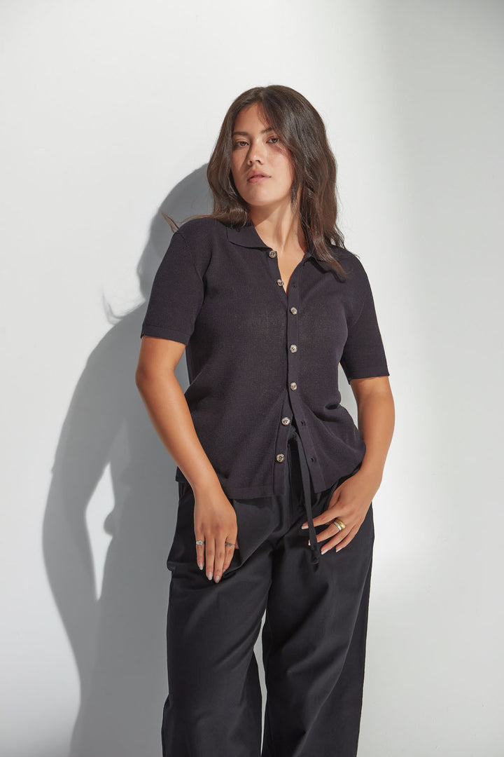 Woman wearing a black outfit against a white background.