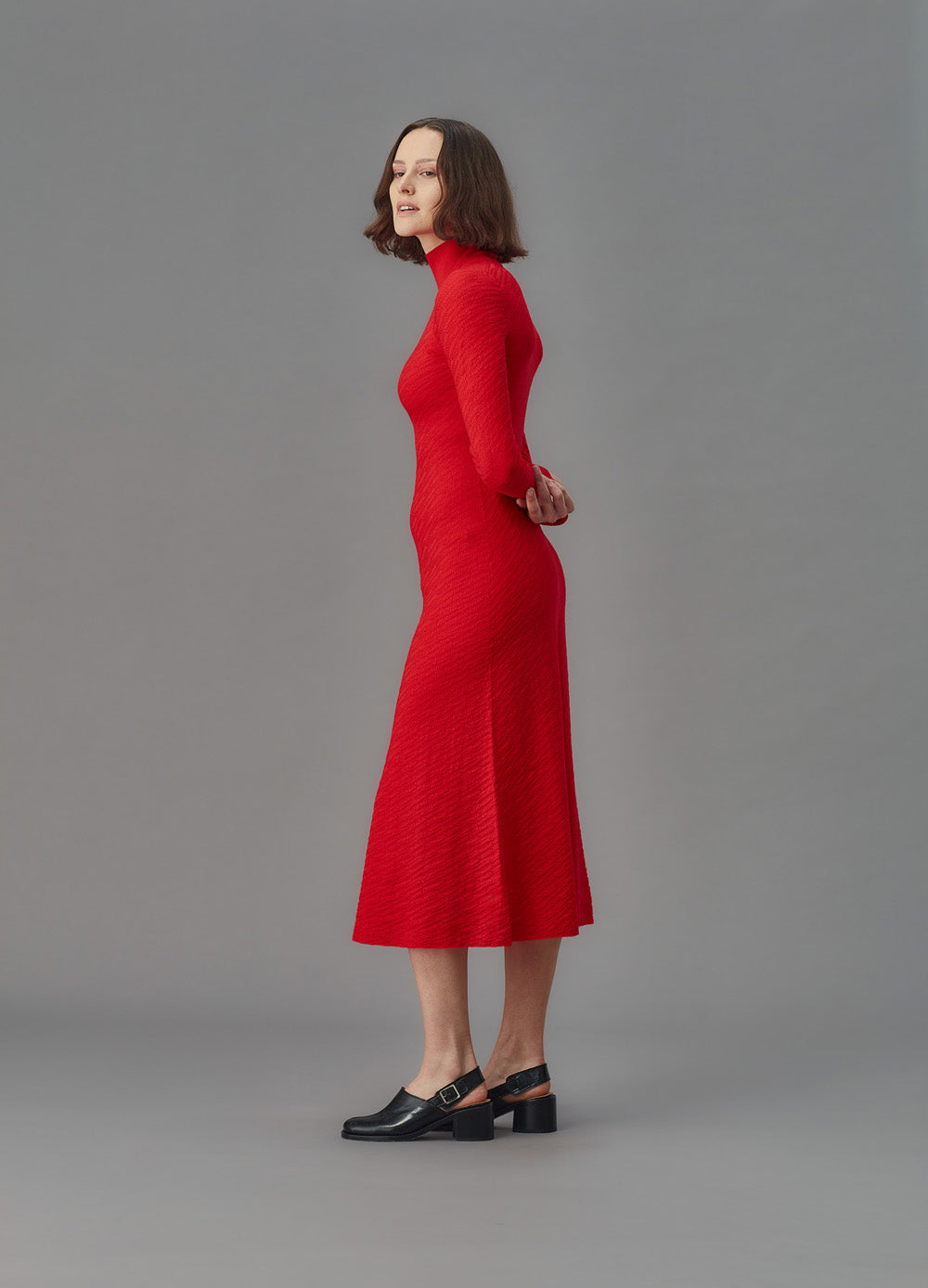 Woman wearing a red dress against a gray background