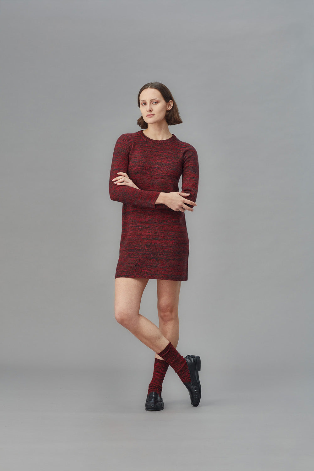 Woman wearing a red patterned dress against a gray background