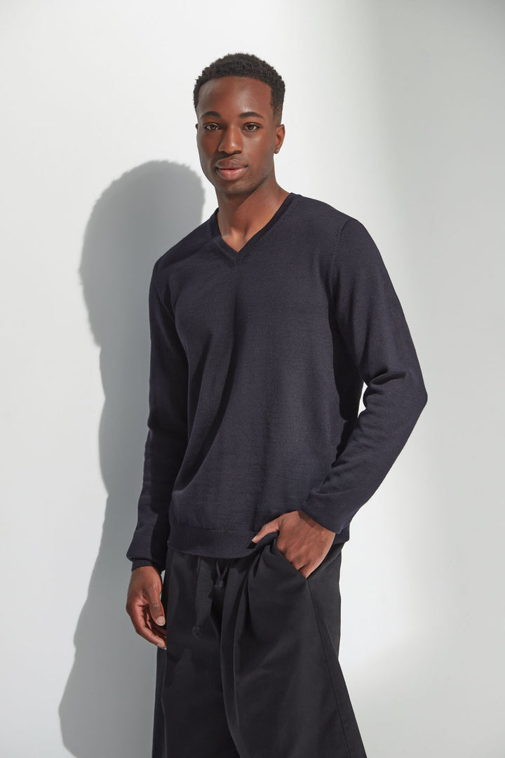 Man wearing a dark navy long-sleeve shirt and black pants against a white background