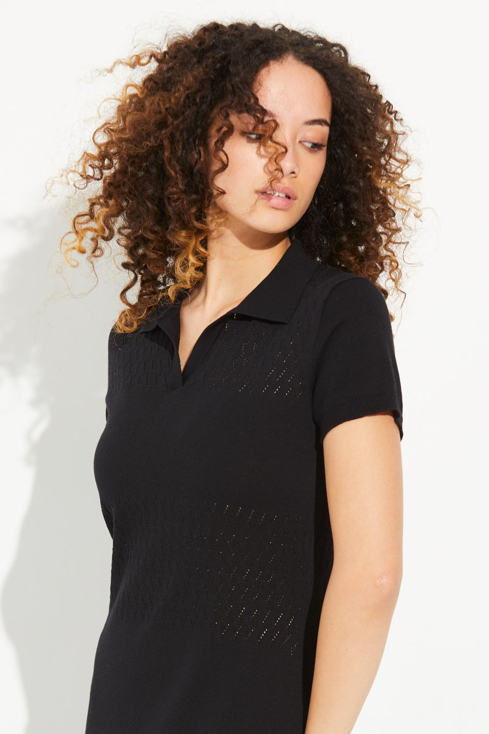 A woman wearing a black Standard Issue Cotton Foliage Polo Dress.