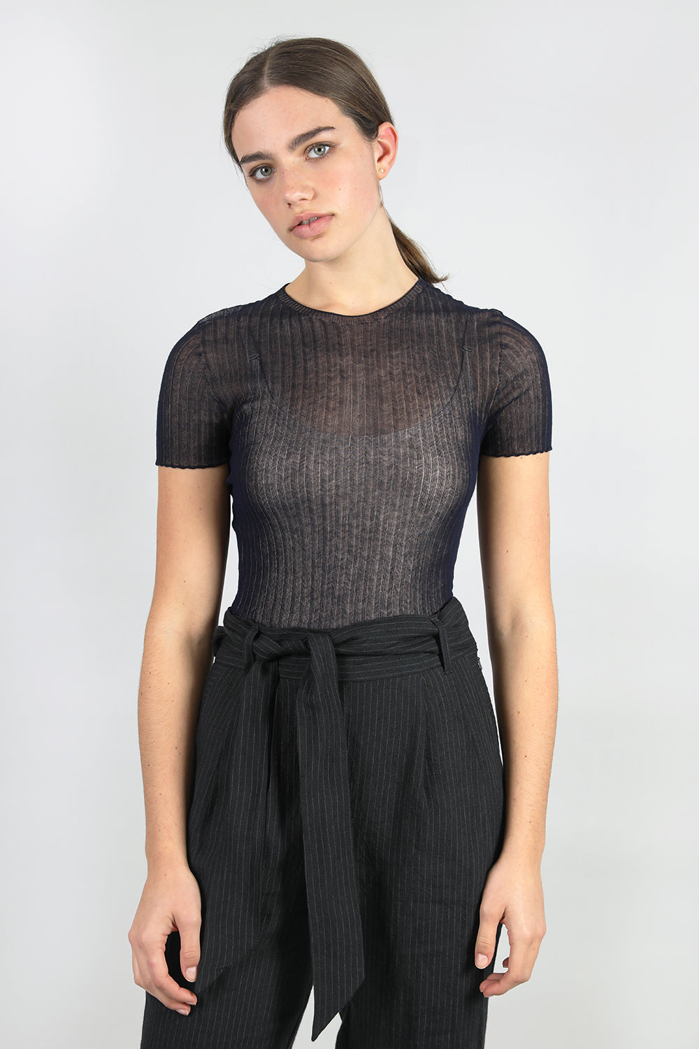 A woman standing wearing a navy Standard Issue Cotton Tulle Crop Tee.
